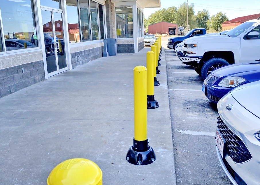 Yellow bollards in parking lot reduce potential hazards of vehicles entering storefront. Yellow bollards in parking lot reduce potential hazards of vehicles entering storefront.